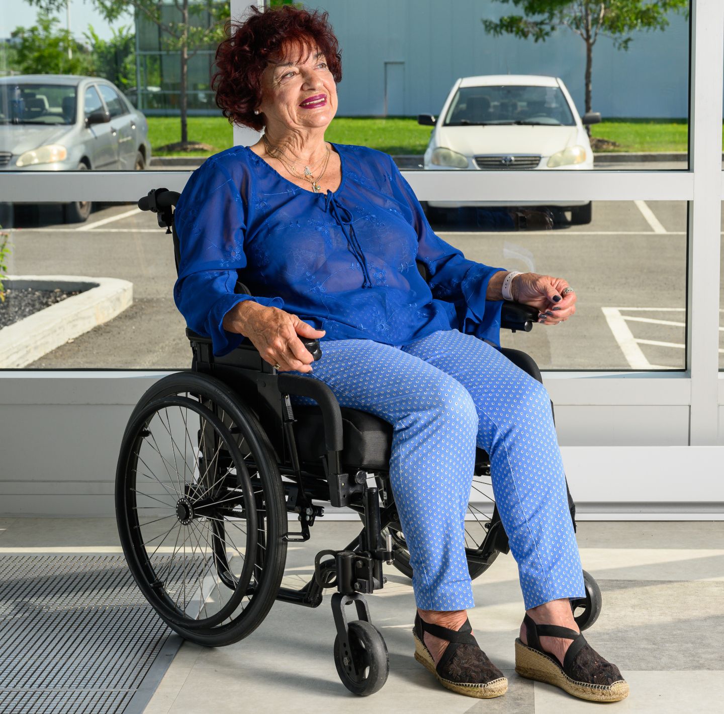 Dame assie dans un fauteuil roulant Dame assie dans un fauteuil roulant Positech